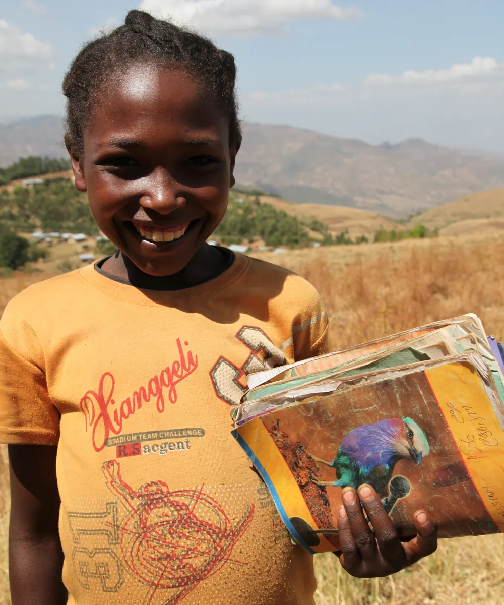 Una bambina sorridente con un quaderno tra le mani, in Etiopia