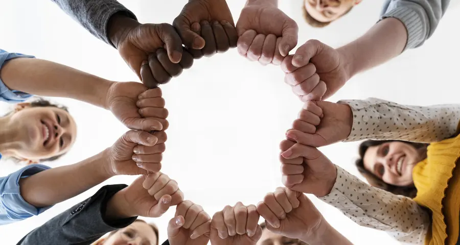 Un cerchio di mani unite viste dal basso
