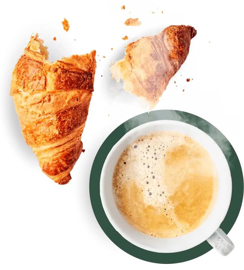 Un croissant spezzato e una tazza di cappuccino visti dall'alto